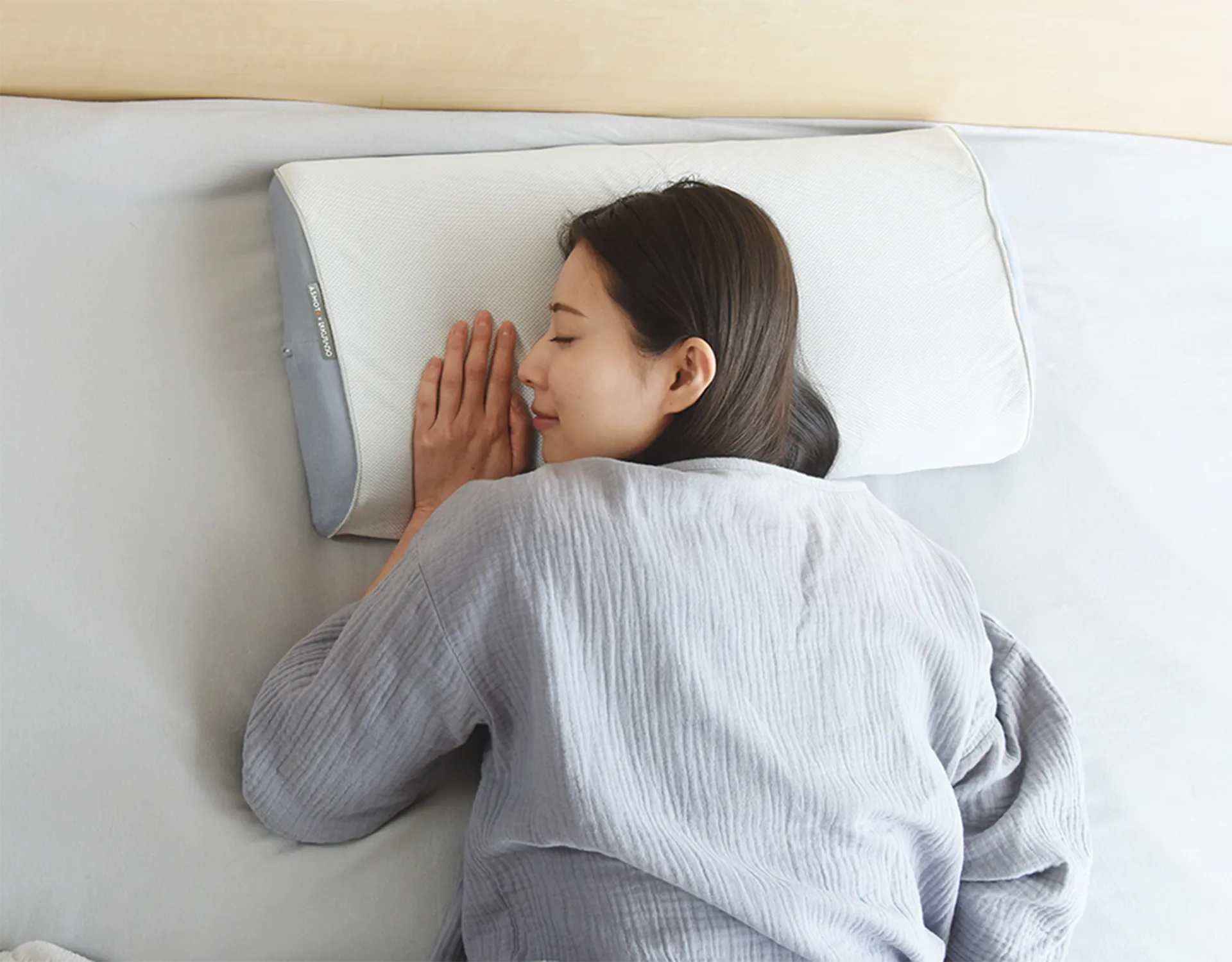 枕に頭を横にしておく女性